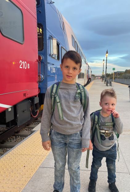 Jaxton and LIam, standng on platform beside FrontRunner