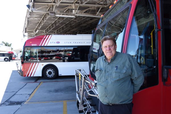 UTA employee Mitch Holmes standing next to a bus